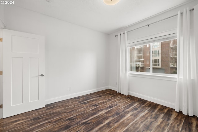 spare room with dark hardwood / wood-style flooring