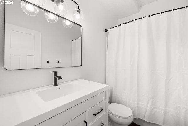 bathroom featuring curtained shower, vanity, and toilet