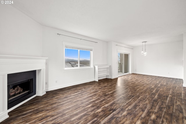 unfurnished living room with dark wood-type flooring and a notable chandelier