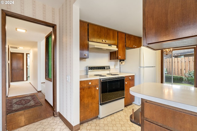 kitchen featuring an inviting chandelier, white appliances, and light parquet flooring