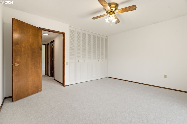 unfurnished bedroom with light carpet, a closet, and ceiling fan