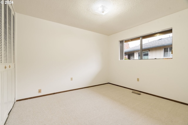 empty room featuring carpet flooring and a textured ceiling