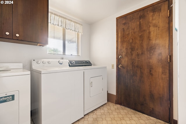 washroom featuring washing machine and clothes dryer and cabinets