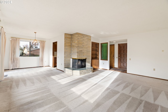 unfurnished living room with a fireplace, light colored carpet, and an inviting chandelier