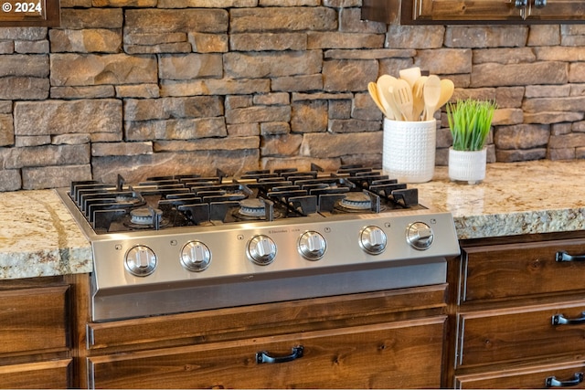 interior details with light stone countertops and stainless steel gas cooktop