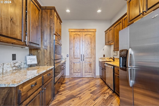 kitchen featuring light stone counters, dark hardwood / wood-style floors, and appliances with stainless steel finishes