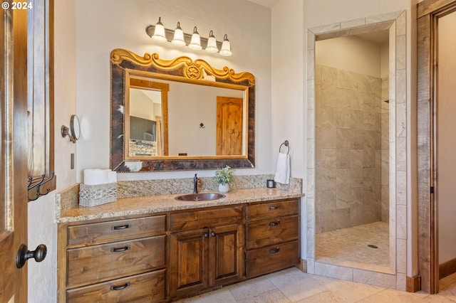 bathroom with tile patterned floors, vanity, and tiled shower