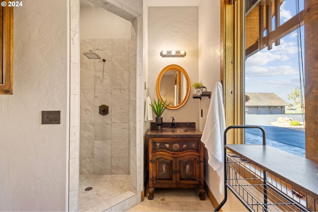 bathroom featuring a tile shower and vanity