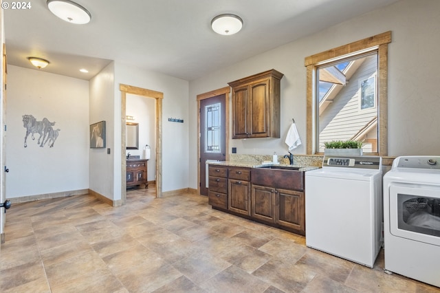 laundry area featuring cabinets, independent washer and dryer, and sink