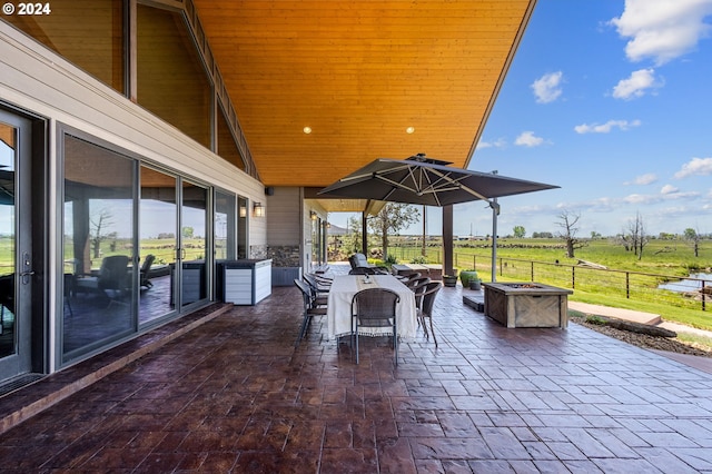 view of patio with a fire pit and a rural view