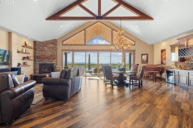 living room featuring dark wood-type flooring, a stone fireplace, bar, beverage cooler, and a chandelier