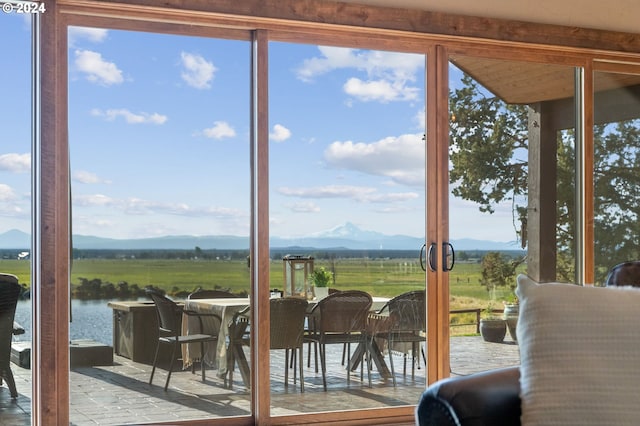 doorway to outside featuring a healthy amount of sunlight, a water and mountain view, and a rural view