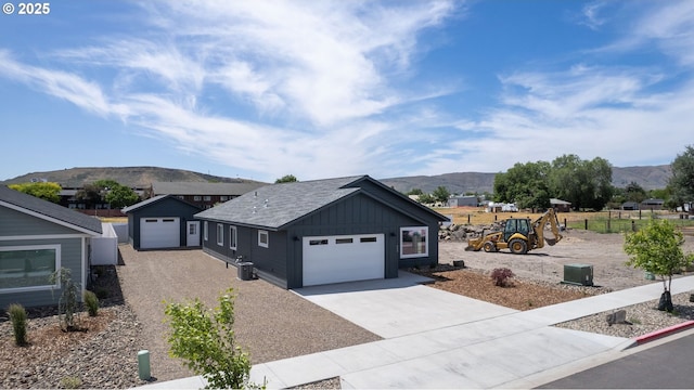 660 E St E, Baker City, OR 97814 - view of front of house featuring a mountain view, concrete driveway, a garage, and board and batten siding
