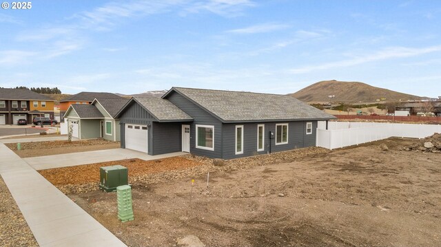 view of front of house with a mountain view, a garage, and central AC unit