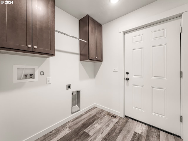 clothes washing area with cabinets, washer hookup, light wood-type flooring, electric dryer hookup, and hookup for a gas dryer