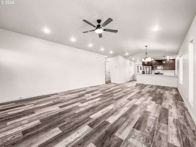 unfurnished living room with wood-type flooring, vaulted ceiling, ceiling fan, and sink