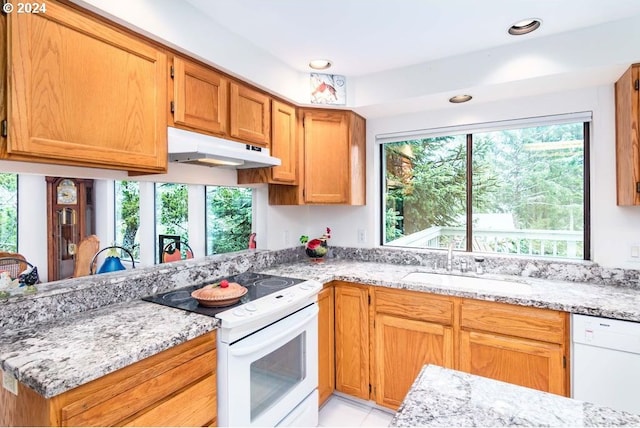 kitchen featuring white appliances, a healthy amount of sunlight, and kitchen peninsula