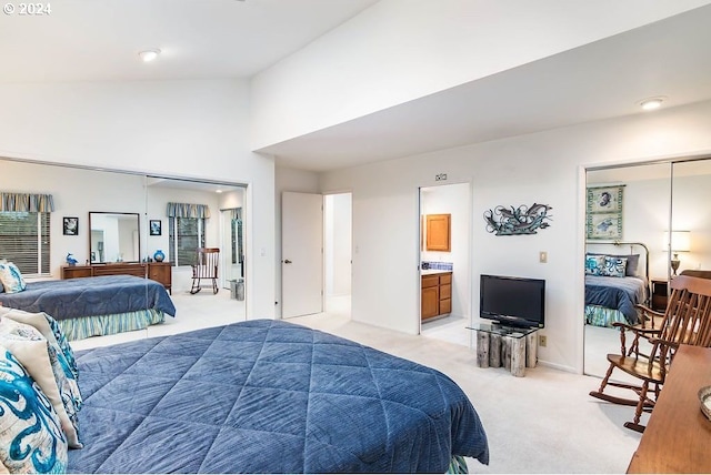 carpeted bedroom with a closet, high vaulted ceiling, and ensuite bathroom