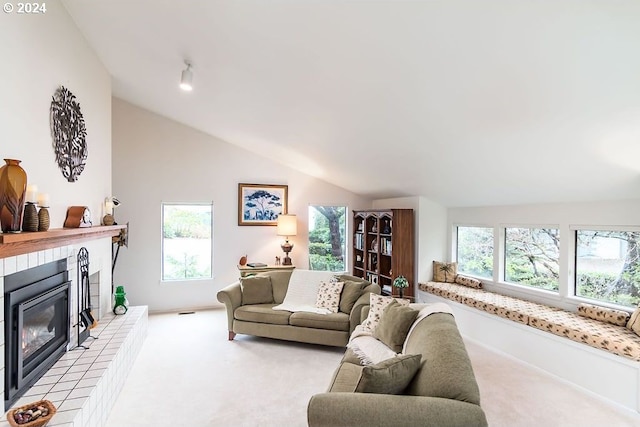 living room with light colored carpet, a fireplace, lofted ceiling, and a healthy amount of sunlight