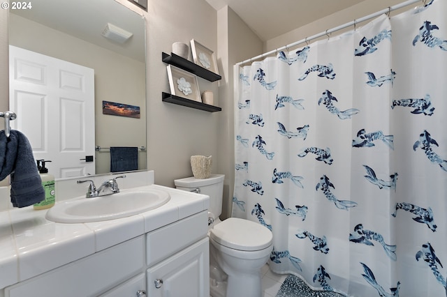 bathroom with curtained shower, vanity, toilet, and tile patterned floors