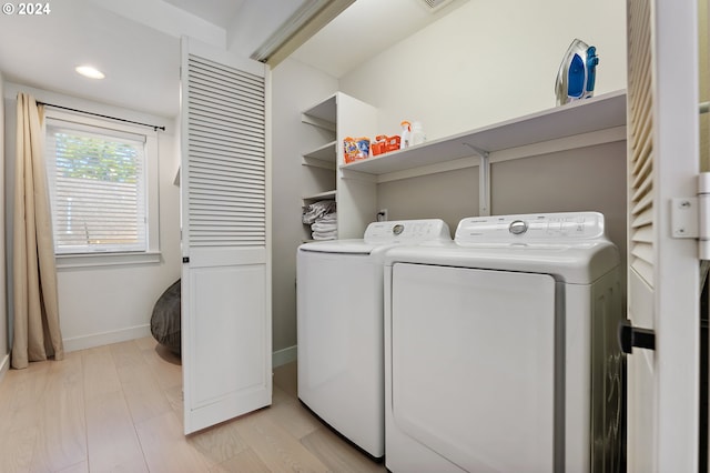 washroom featuring washing machine and clothes dryer and light wood-type flooring