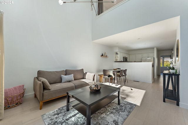 living room featuring light wood-type flooring and a chandelier