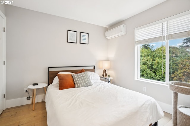 bedroom featuring an AC wall unit and light wood-type flooring