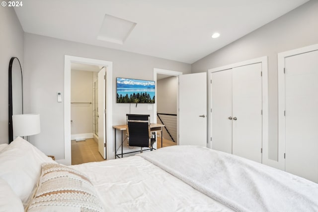 bedroom with connected bathroom and vaulted ceiling