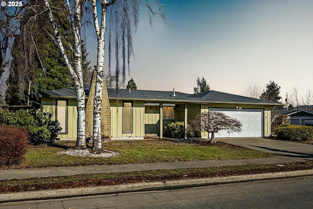 ranch-style house featuring a garage and a lawn