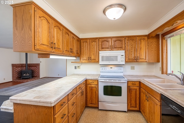 kitchen featuring sink, tile countertops, a wood stove, kitchen peninsula, and white appliances