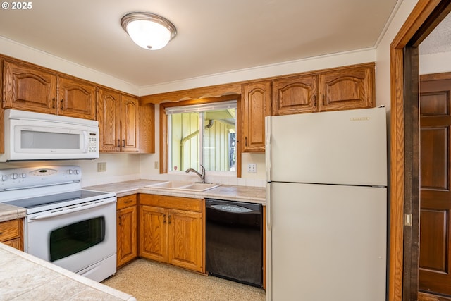 kitchen featuring sink, tile countertops, and white appliances