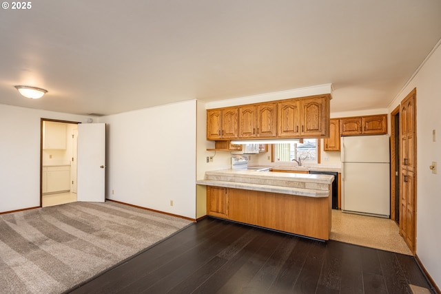 kitchen featuring dark hardwood / wood-style floors, dishwasher, stainless steel range with electric cooktop, white fridge, and kitchen peninsula