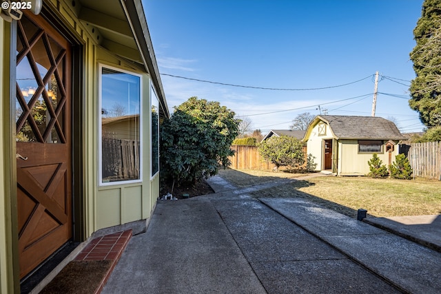 view of side of property with a shed, a yard, and a patio area