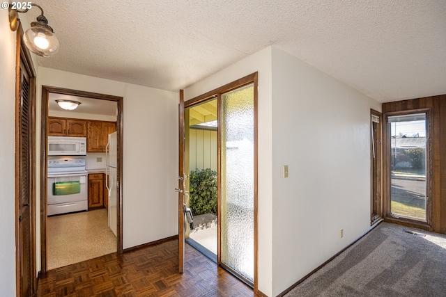 corridor featuring dark parquet flooring and a textured ceiling