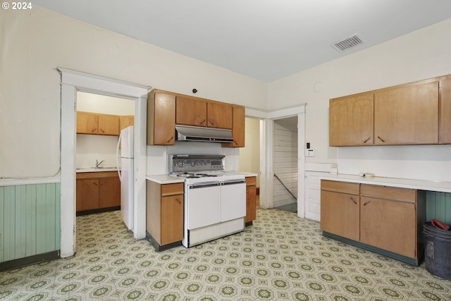 kitchen with sink, white appliances, and light tile flooring