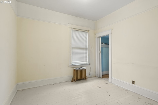 empty room featuring light hardwood / wood-style flooring and radiator heating unit