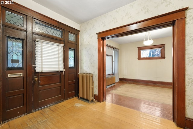 foyer entrance with light wood-type flooring and radiator