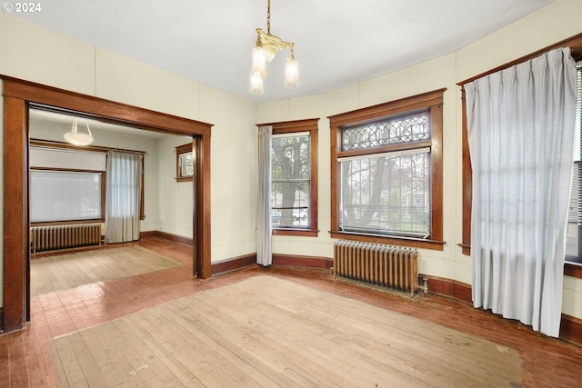 unfurnished room featuring hardwood / wood-style floors and radiator