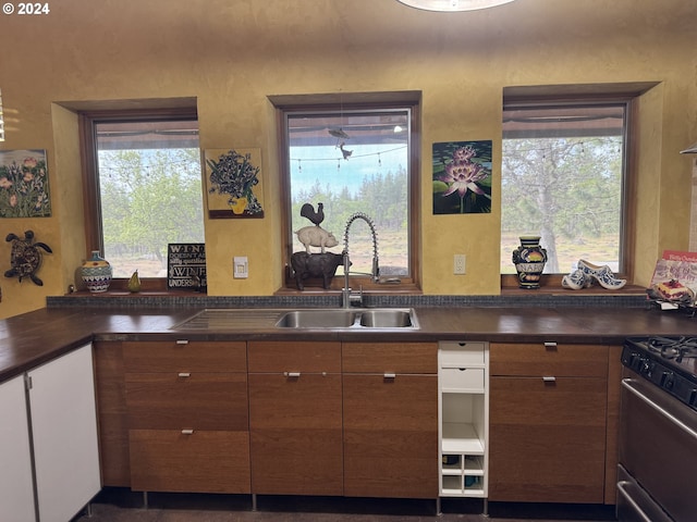 44 Justanother Rd, Goldendale, WA 98620 - kitchen featuring a sink, dark countertops, stainless steel range with gas cooktop, and brown cabinetry