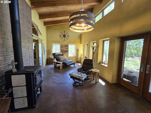 44 Justanother Rd, Goldendale, WA 98620 - living area with finished concrete flooring, a wood stove, a high ceiling, a chandelier, and wood ceiling with exposed beams