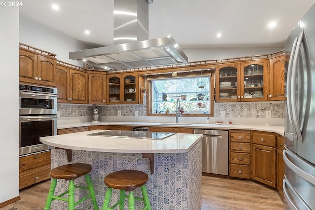 kitchen with sink, stainless steel appliances, island exhaust hood, vaulted ceiling, and light wood-type flooring