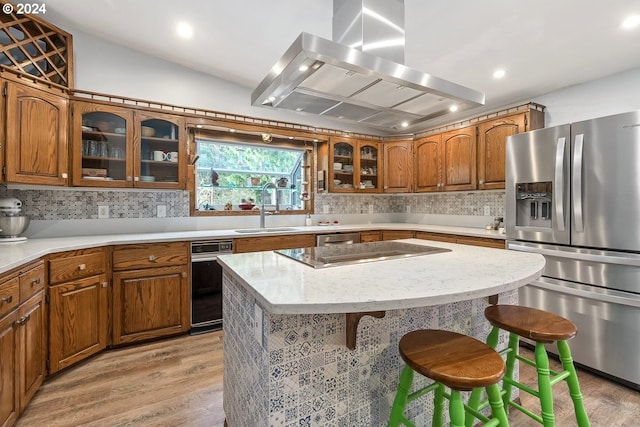 kitchen with backsplash, light wood-type flooring, island exhaust hood, and appliances with stainless steel finishes