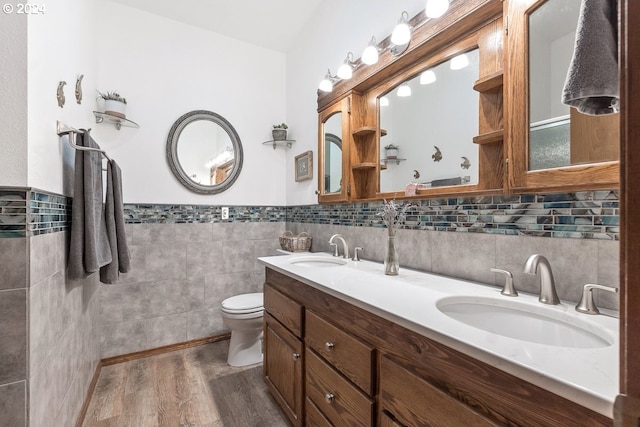 bathroom with hardwood / wood-style floors, vanity, toilet, and tile walls