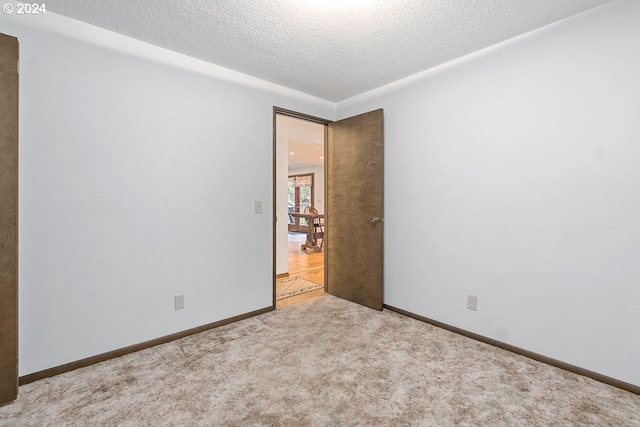 carpeted empty room featuring a textured ceiling