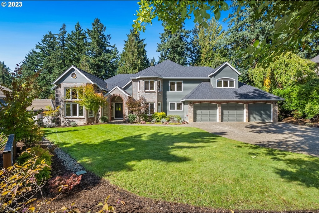 view of front of house with a garage and a front lawn