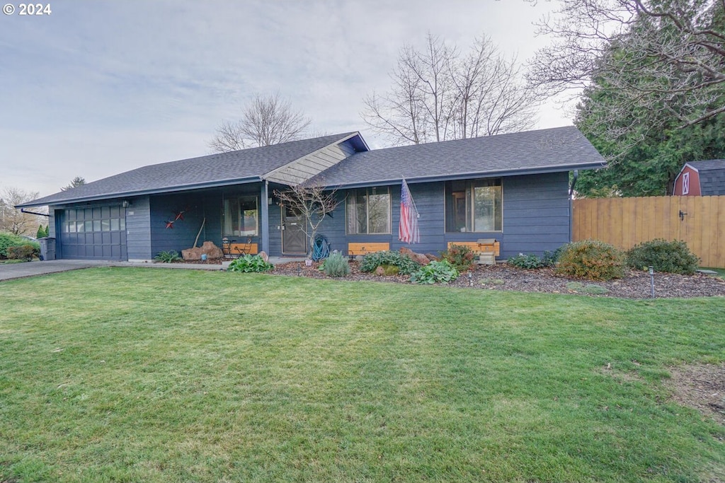 ranch-style house featuring a garage and a front lawn