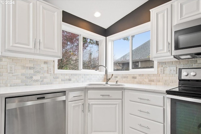 kitchen featuring white cabinets, stainless steel appliances, tasteful backsplash, and sink