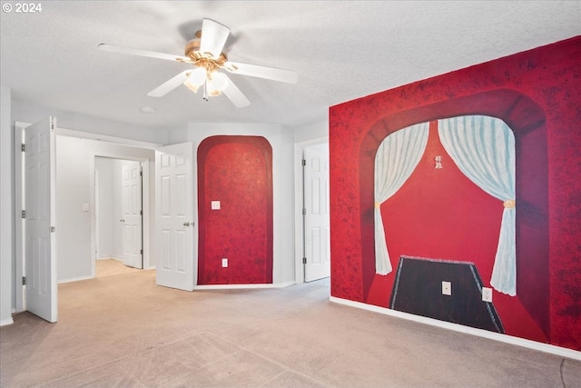 carpeted empty room with ceiling fan and a textured ceiling