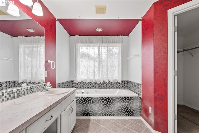 bathroom with tiled tub and vanity