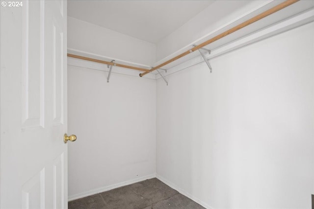 walk in closet featuring dark colored carpet